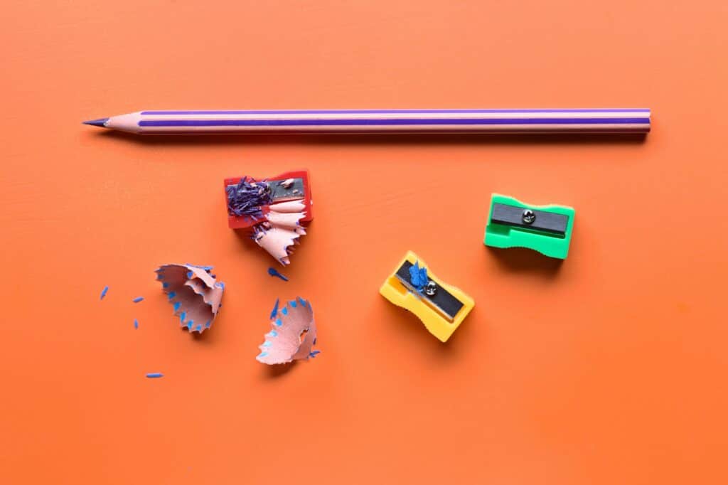 colored pencils and pencil sharpener on orange board